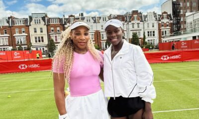 Serena Williams in a pink top and Victoria Mboko in a white jacket standing together on the grass courts at the HSBC Championships at Queen's Club in London.