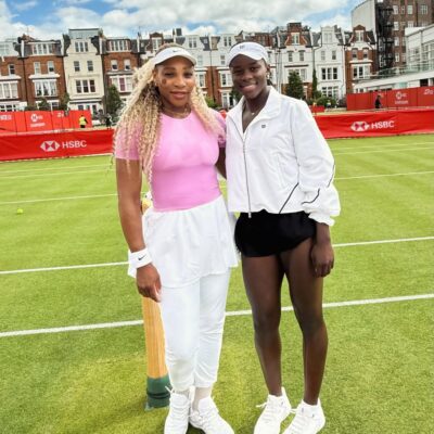 Serena Williams in a pink top and Victoria Mboko in a white jacket standing together on the grass courts at the HSBC Championships at Queen's Club in London.