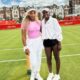 Serena Williams in a pink top and Victoria Mboko in a white jacket standing together on the grass courts at the HSBC Championships at Queen's Club in London.