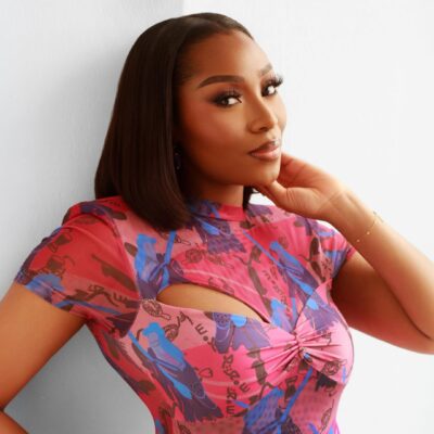 Close-up of beauty influencer Dimma Umeh showcasing a soft-glam matte makeup look and a sleek, middle-parted straight bob hairstyle.