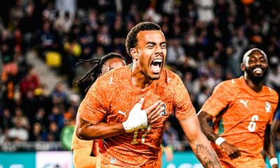 Ivory Coast forward Simon Adingra celebrating with teammates in their orange kit after scoring against France during a pre-World Cup 2026 friendly match.