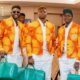 Côte d'Ivoire players Ibrahim Sangaré, Emmanuel Agbadou, and Wilfried Singo walking together with green and orange luxury travel luggage in their formal team suits.