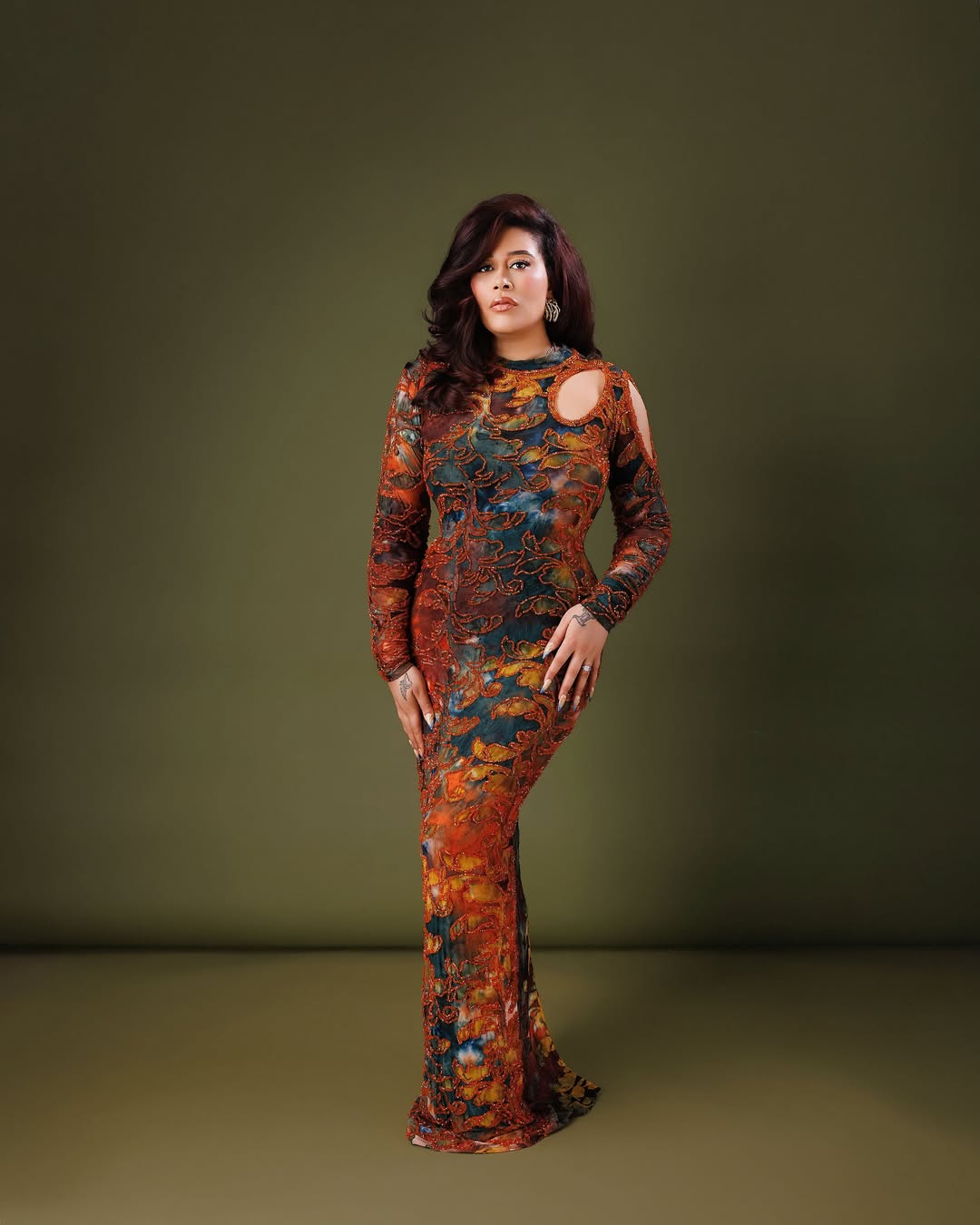 Nigerian actress Adunni Ade posing in a long-sleeved, earth-toned embellished maxi gown with an asymmetric shoulder cutout for her 2026 birthday.