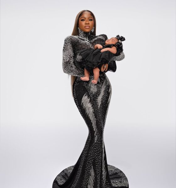 Fashion designer Veekee James holding her newborn daughter Eliana Adeife Atere in a coordinating black ruffled outfit for her 31st birthday.