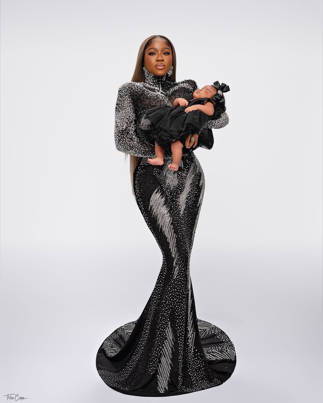 Fashion designer Veekee James holding her newborn daughter Eliana Adeife Atere in a coordinating black ruffled outfit for her 31st birthday.