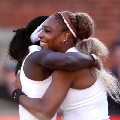 Serena Williams smiling warmly while embracing her doubles partner Victoria Mboko following their straight-sets victory.
