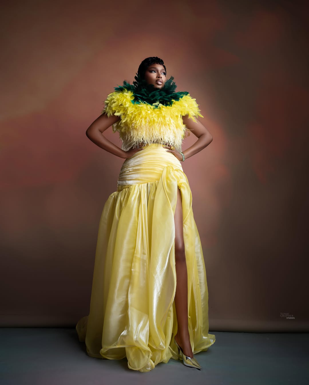 Sabrina Idukpaye in a canary yellow organza skirt with a high leg slit and a long flowing train.