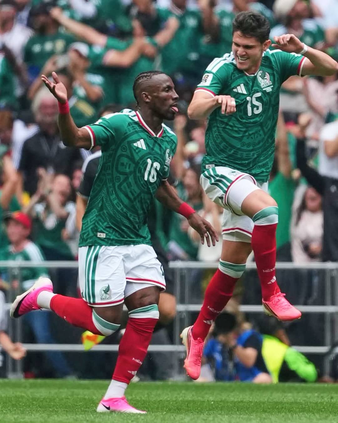 Julián Quiñones running and celebrating the opening goal for Mexico on the pitch at Estadio Azteca.