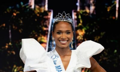 Maureen-Alycia Lucéa-Merlin wearing the Miss Martinique 2026 sash, crown, and gold drop earrings with her hands on her hips.