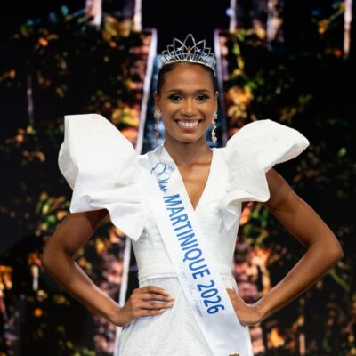 Maureen-Alycia Lucéa-Merlin wearing the Miss Martinique 2026 sash, crown, and gold drop earrings with her hands on her hips.