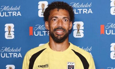 Cabo Verde goalkeeper Vozinha holding his official FIFA World Cup Man of the Match trophy in front of a blue sponsor backdrop.