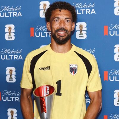 Cabo Verde goalkeeper Vozinha holding his official FIFA World Cup Man of the Match trophy in front of a blue sponsor backdrop.