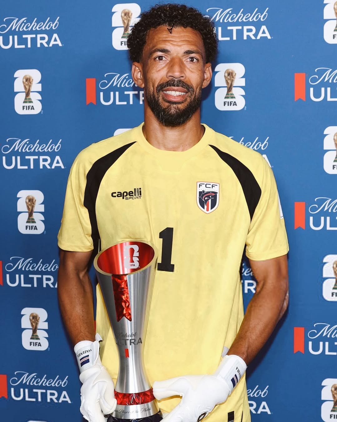 Cabo Verde goalkeeper Vozinha holding his official FIFA World Cup Man of the Match trophy in front of a blue sponsor backdrop.