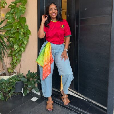 Actress Joselyn Dumas styles a retro red Ghana national team football jersey with wide-leg denim jeans for the 2026 FIFA World Cup fixture against Panama.