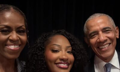 Smiling selfie featuring Michelle Obama, Nigerian musician Tems, and former US President Barack Obama together at the Obama Presidential Center in Chicago.