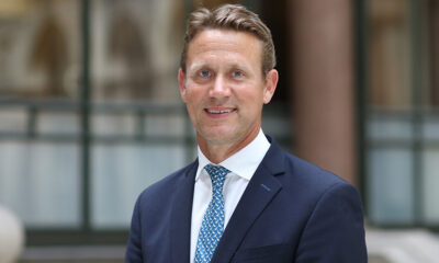 A professional portrait of Peter Vowles, the newly appointed British High Commissioner to Nigeria, wearing a navy blue suit and patterned tie, smiling outdoors.