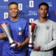 Kylian Mbappé holding the silver FIFA Player of the Match trophy next to Jude Bellingham holding his respective Michelob Ultra Player of the Match award.