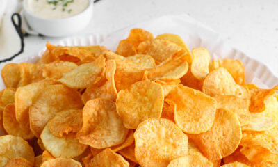 A white bowl filled with crunchy, golden-brown homemade sweet potato chips made from Nigerian white sweet potatoes, served with a side dip.
