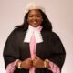 Akolade Oduwaiye wearing the traditional Nigerian Law School wig, barrister gown, and lace-trimmed pink legal attire.