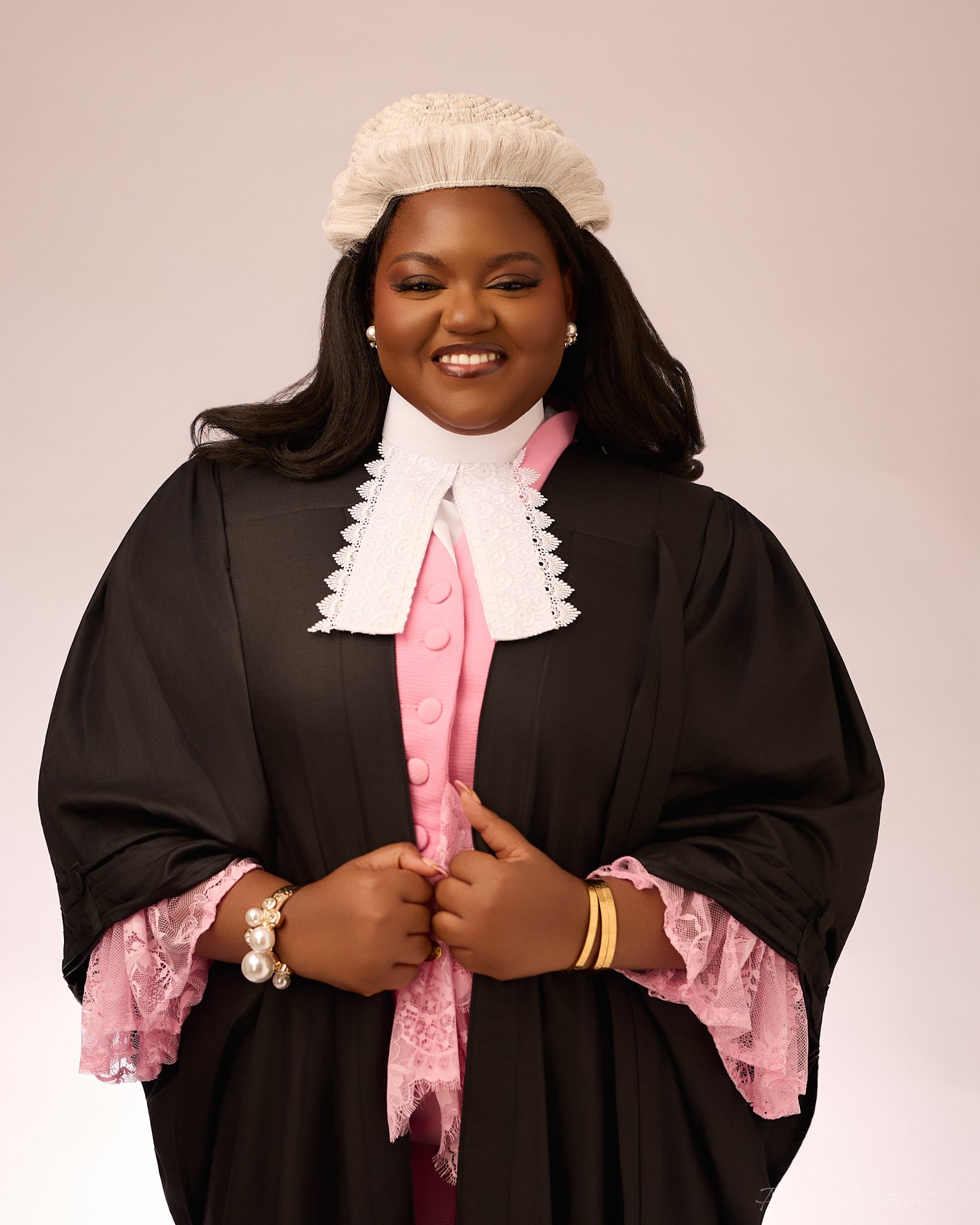 Akolade Oduwaiye wearing the traditional Nigerian Law School wig, barrister gown, and lace-trimmed pink legal attire.
