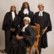Four female Nigerian lawyers wearing traditional white legal wigs, collared bands, and black barrister gowns during the Call to the Bar ceremony.