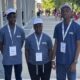 Don Anele Munachimso Marvelous, Egejurum Onyedikachi Ethan, and Chimdiebube Onwubiko wearing blue STEM Olympiad shirts and white caps outside Università Campus Bio-Medico di Roma.