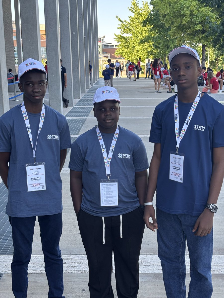 Don Anele Munachimso Marvelous, Egejurum Onyedikachi Ethan, and Chimdiebube Onwubiko wearing blue STEM Olympiad shirts and white caps outside Università Campus Bio-Medico di Roma.