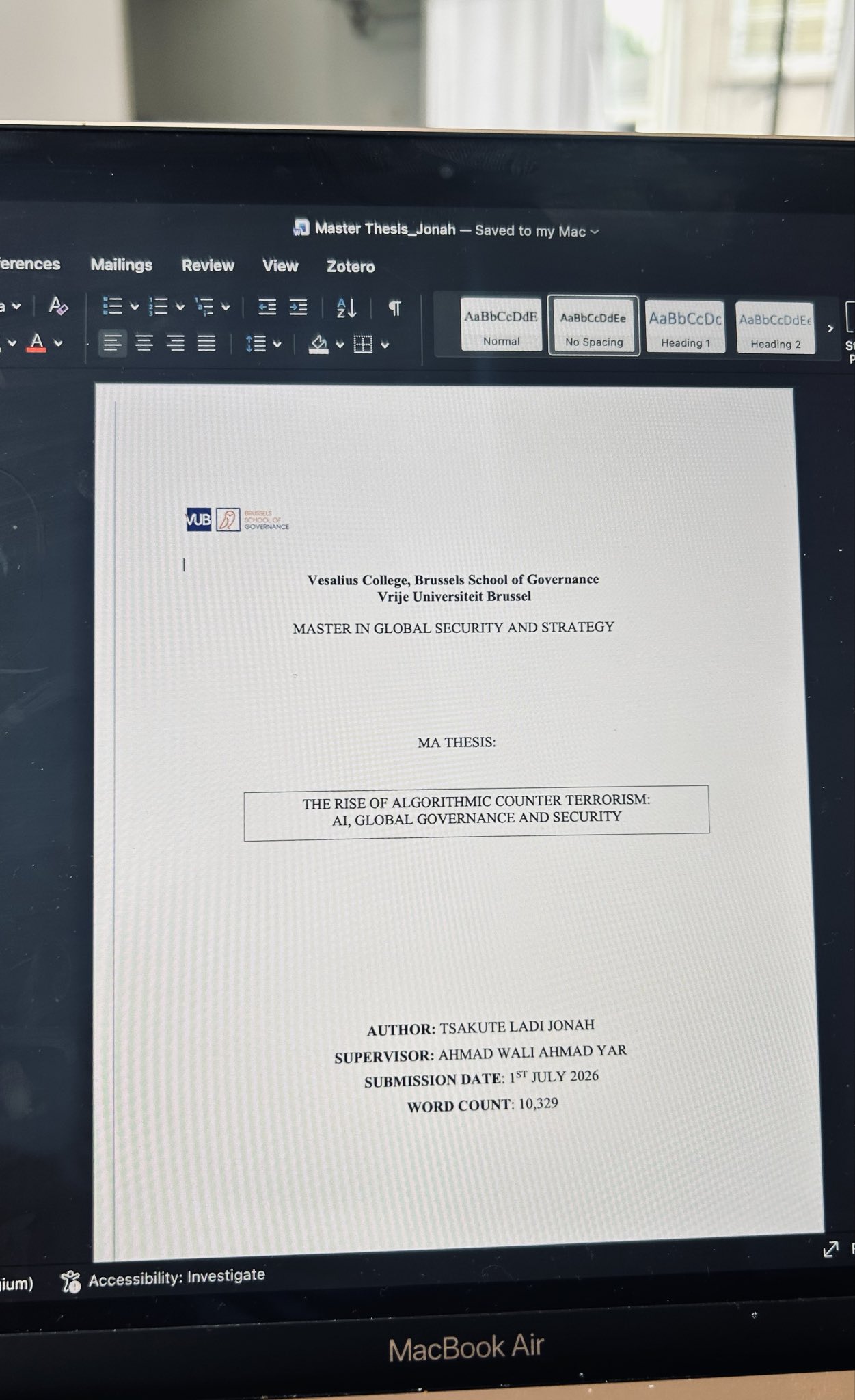 A MacBook Air screen displaying Tsakute Ladi Jonah's Master's thesis title page for the Brussels School of Governance, Vrije Universiteit Brussel.
