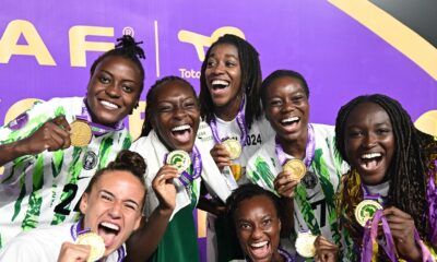 Nigeria Super Falcons players Asisat Oshoala, Ifeoma Onumonu, Deborah Abiodun, Ashleigh Plumptre, Toni Payne, and Jennifer Echegini displaying gold winner medals after defeating Morocco in the 2024 WAFCON final.