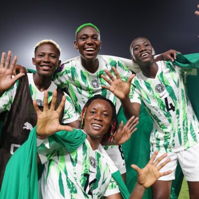 Nigeria players Shukurat Oladipo, Asisat Oshoala, Esther Okoronkwo, and Deborah Abiodun holding up ten fingers on the pitch to celebrate winning 10 WAFCON championships in team history.