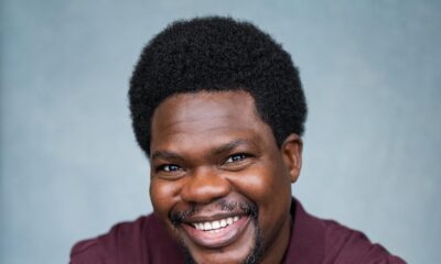 Nigerian actor Debo Adedayo, professionally known as Mr Macaroni, smiling in a maroon polo shirt for his official acting headshot.