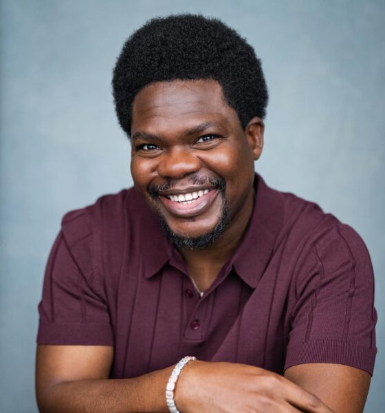 Nigerian actor Debo Adedayo, professionally known as Mr Macaroni, smiling in a maroon polo shirt for his official acting headshot.