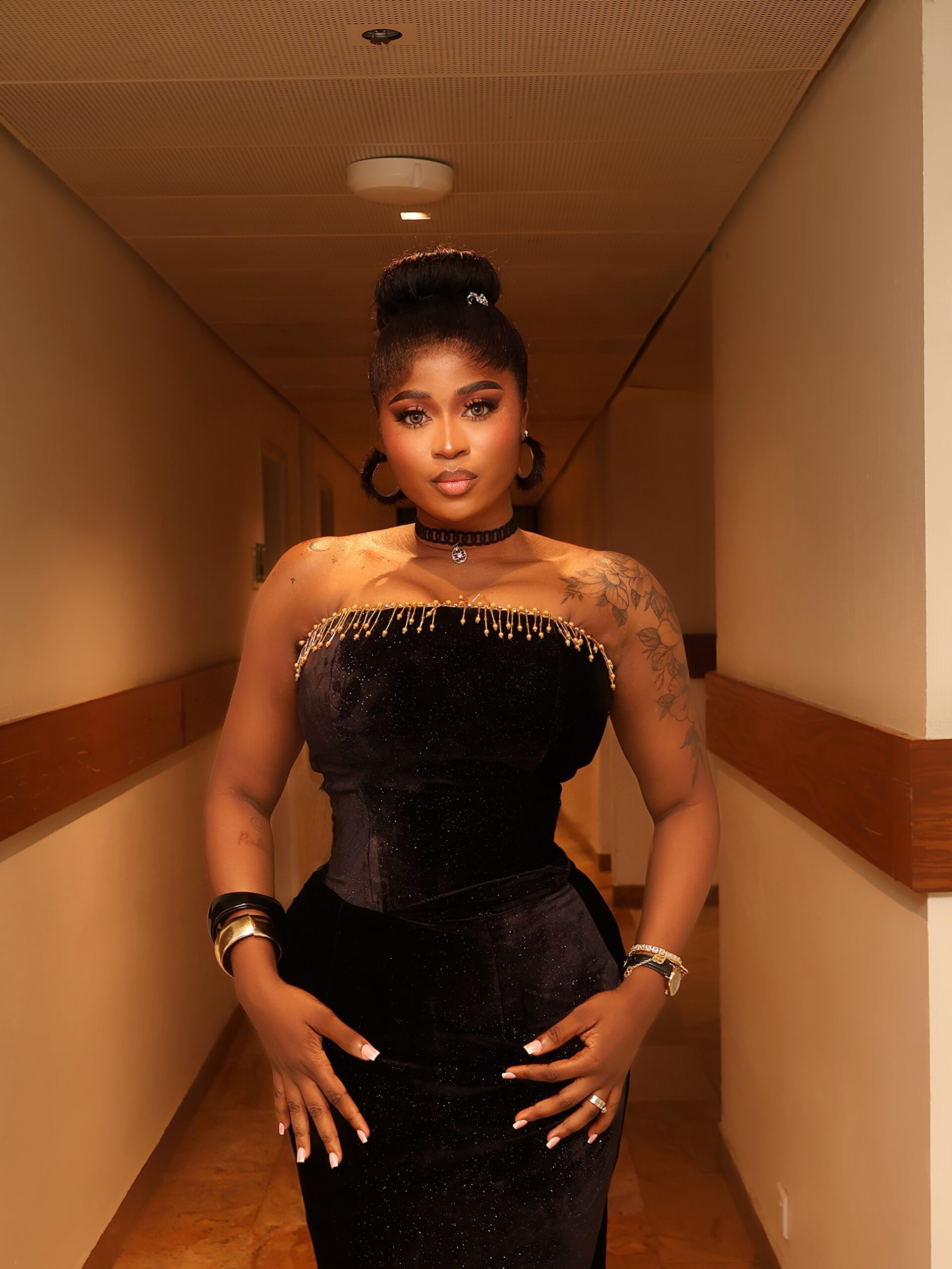 Big Brother Naija Season 10 winner Imisi Ayanwale wearing a strapless black velvet corset gown with beaded detailing at AMVCA 2026.