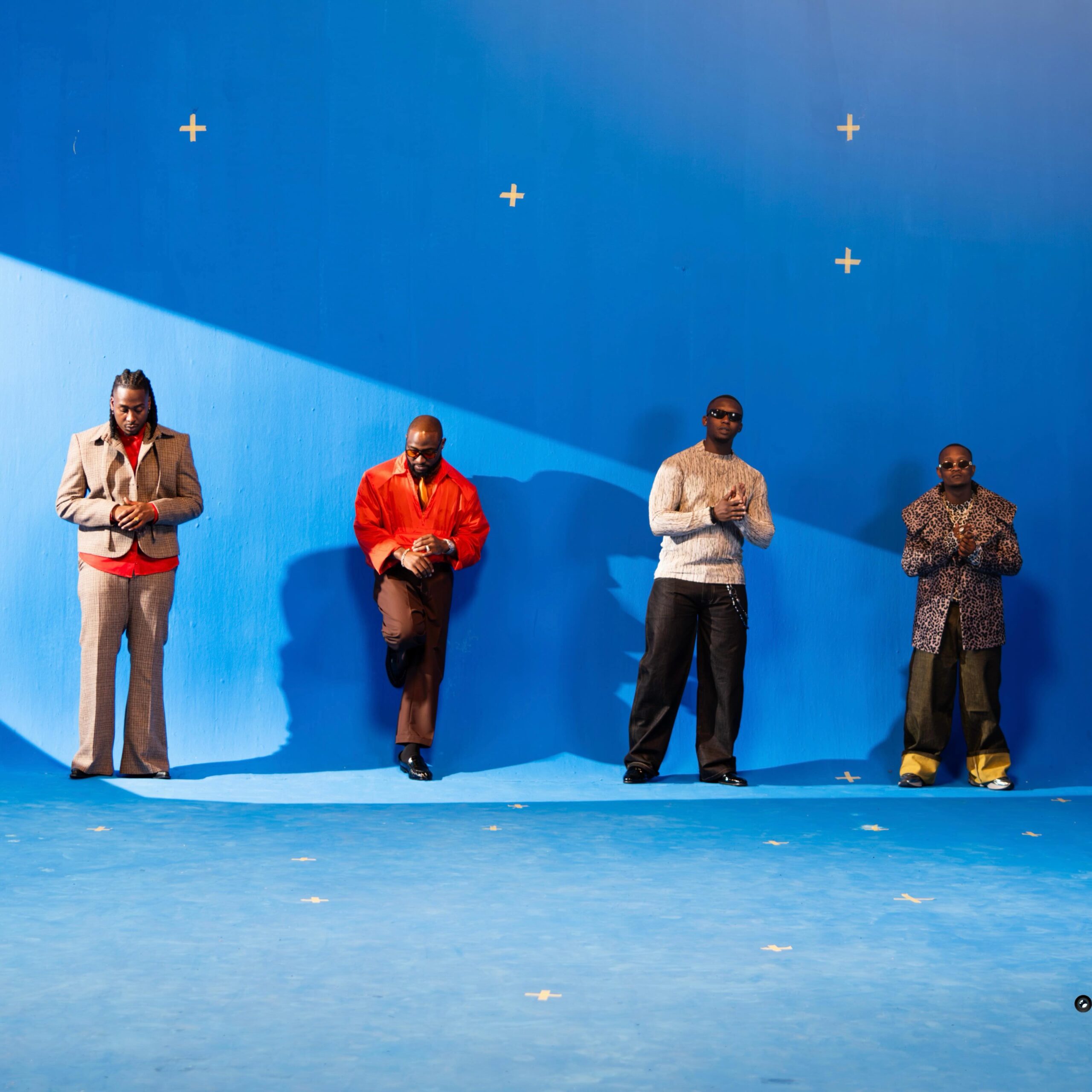 Official music video still from I Know Who I Be featuring Davido alongside South African producers JAZZWRLD and GL Ceejay standing against a vibrant blue studio backdrop.