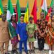 Six Team Nigeria secondary school student representatives dressed in traditional African attire standing in front of continental flags at the Pan-African Mathematics Olympiad in Yamoussoukro Ivory Coast.