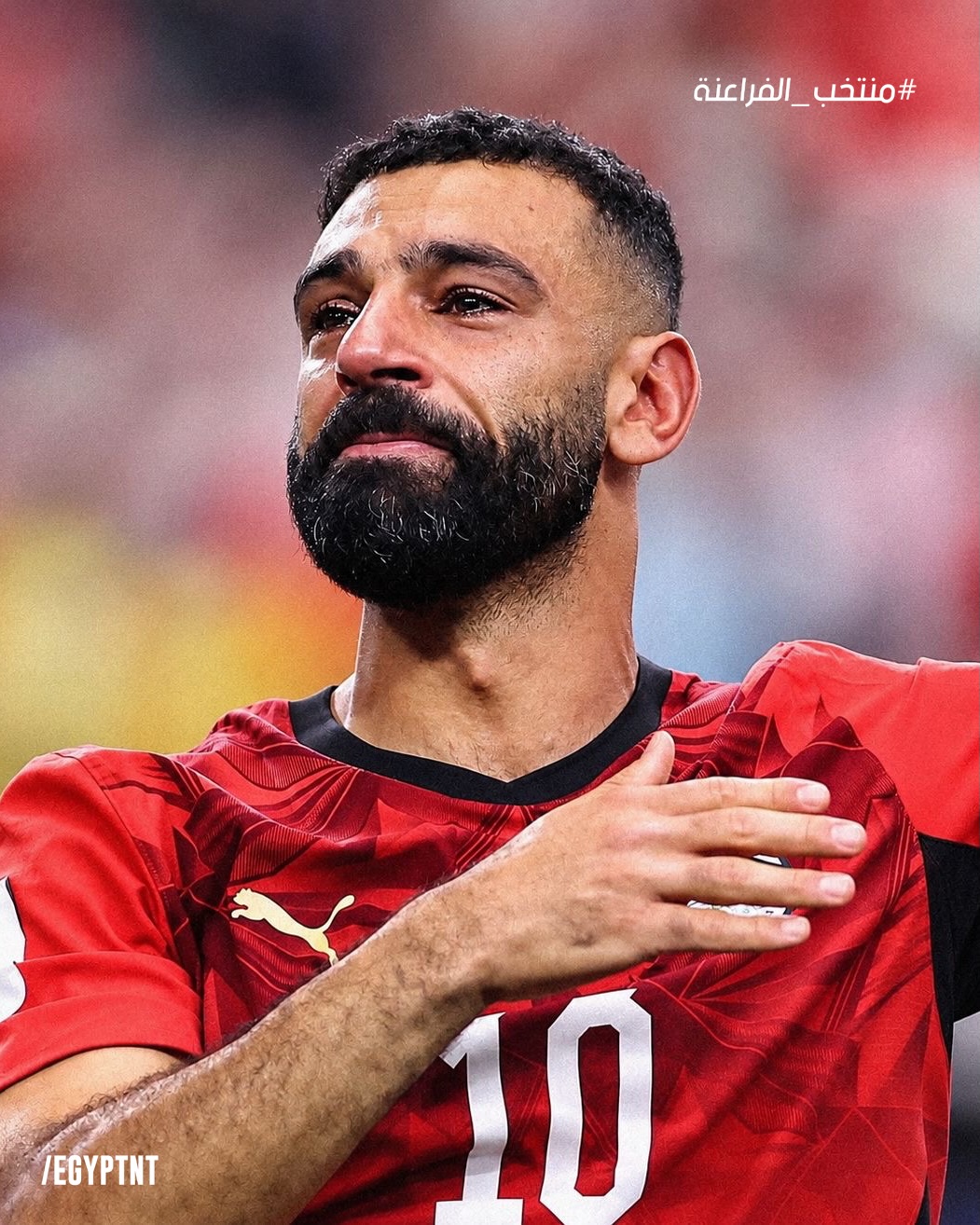 An emotional Mohamed Salah with tears in his eyes, holding his hand over his chest in his number 10 Egypt jersey after qualifying for the World Cup Round of 16.