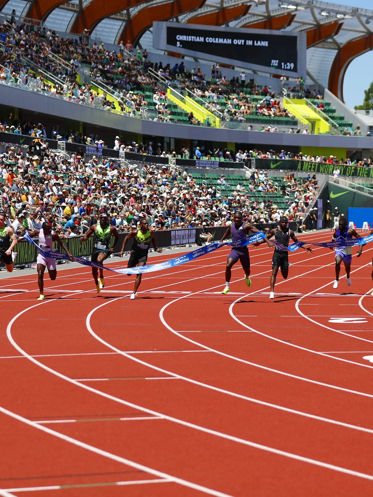 Kanyinsola Ajayi dipping at the finish line to win the men's 100m race ahead of Oblique Seville and Christian Coleman.