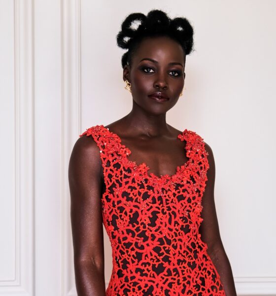 Lupita Nyong'o in a coral-red open-work lace Chanel dress, with architectural natural hair loops and smoky eye makeup by Nick Barose.