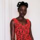 Lupita Nyong'o in a coral-red open-work lace Chanel dress, with architectural natural hair loops and smoky eye makeup by Nick Barose.
