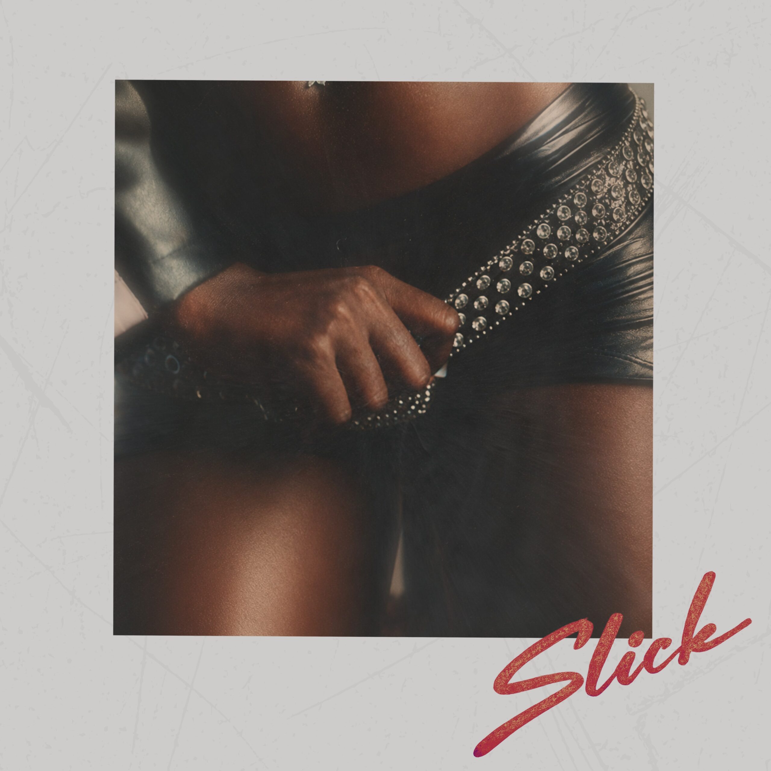 The official single artwork for Slick by Victony featuring a hand resting on a studded black leather belt and leather shorts.