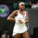 Coco Gauff smiling and hitting her signature "clock it" victory gesture on Centre Court after winning her Wimbledon quarter-final.