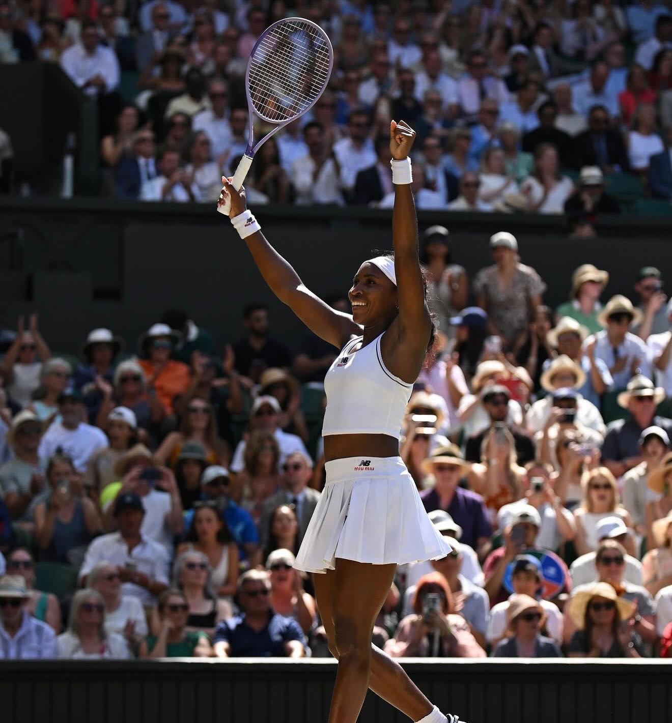 Coco Gauff raising her arms to acknowledge the cheering crowd on Centre Court after making tennis history.