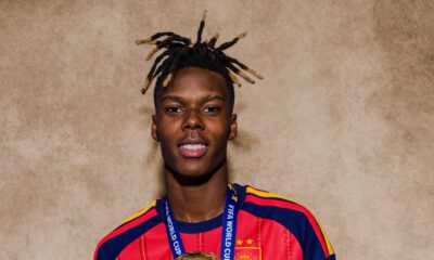 Nico Williams wears his Spain national team kit and winner medal while holding the FIFA World Cup trophy.