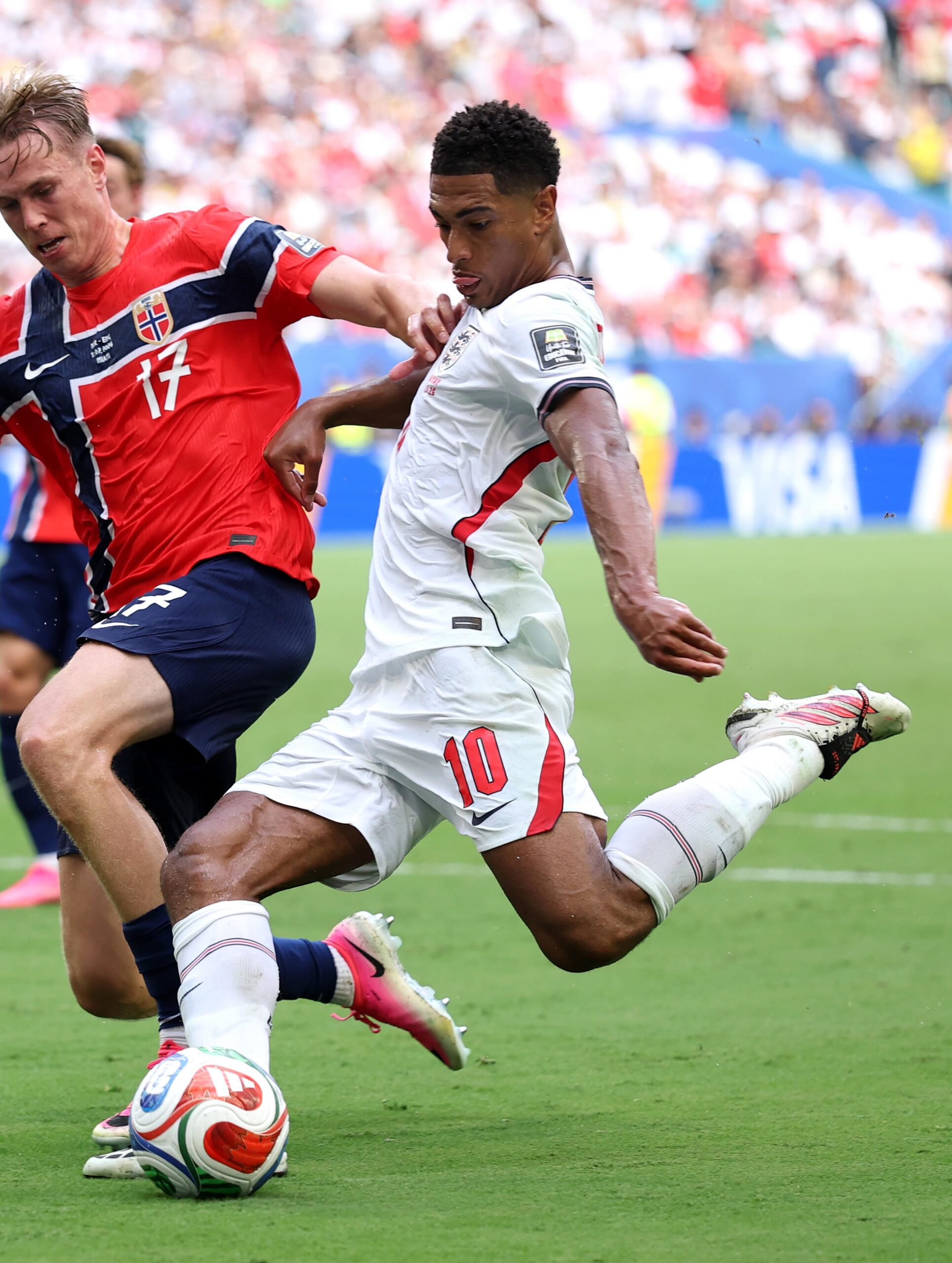 England midfielder Jude Bellingham striking a football mid-air past a Norway defender during the 2026 FIFA World Cup knockout stage match.