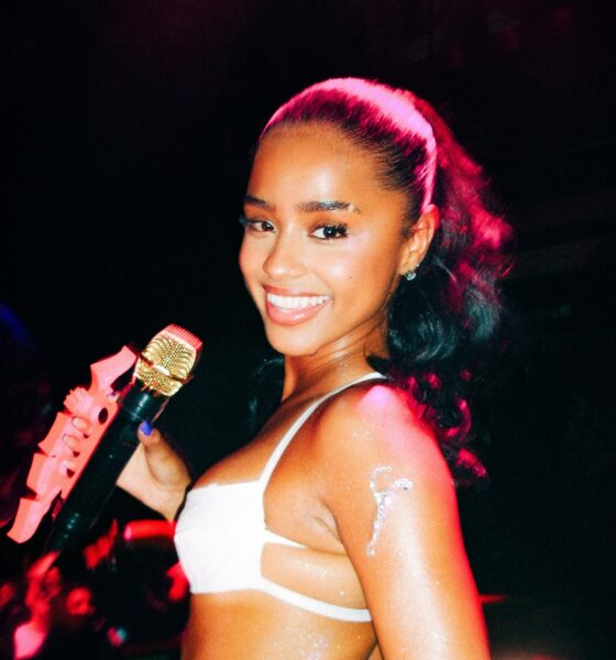 Tyla performing live on stage with a microphone during a concert performance.