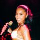 Tyla performing live on stage with a microphone during a concert performance.