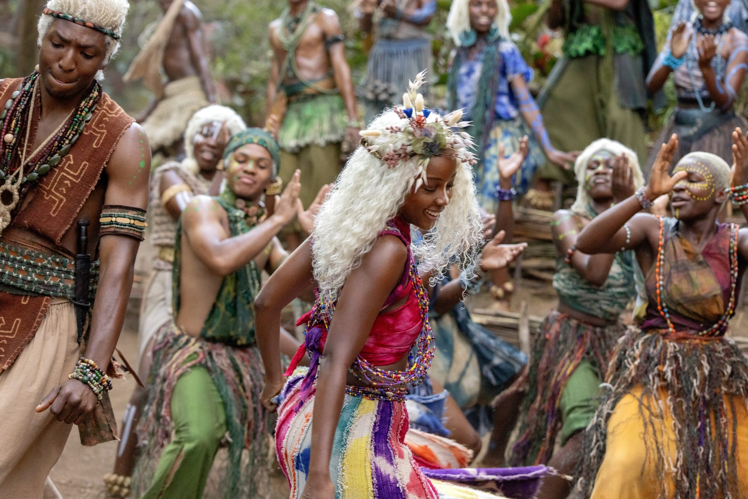Thuso Mbedu as Zélie Adebola dancing during a Maji community celebration with Shamz Garuba dancing on the far left.