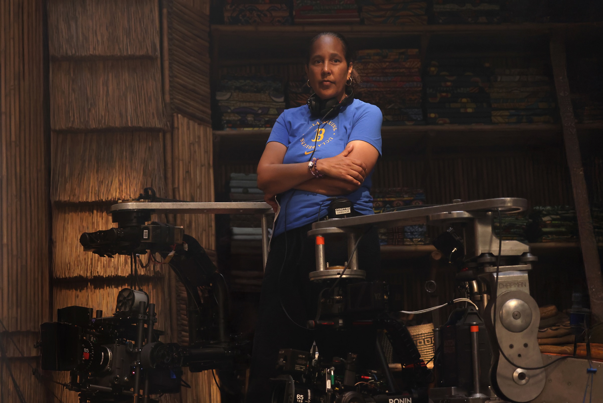 Director Gina Prince-Bythewood standing on the set of the Children of Blood and Bone film adaptation with camera equipment in the foreground.
