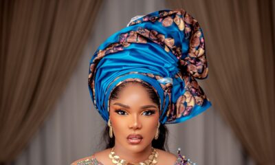 Iyabo Ojo in a detailed turquoise and purple illusion corset gown, showcasing the structured metallic gele and gold choker necklace.