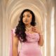 Nollywood actress Linda Ejiofor-Suleiman wearing a custom rose-pink satin dress with 3D embellished floral appliqués and a pearl necklace.